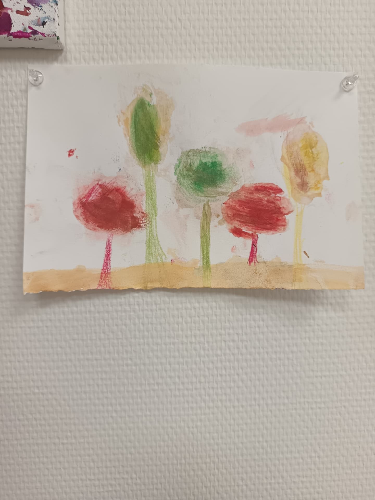 Aquarelle d'arbres colorés réalisée par un jeune élève de l'atelier