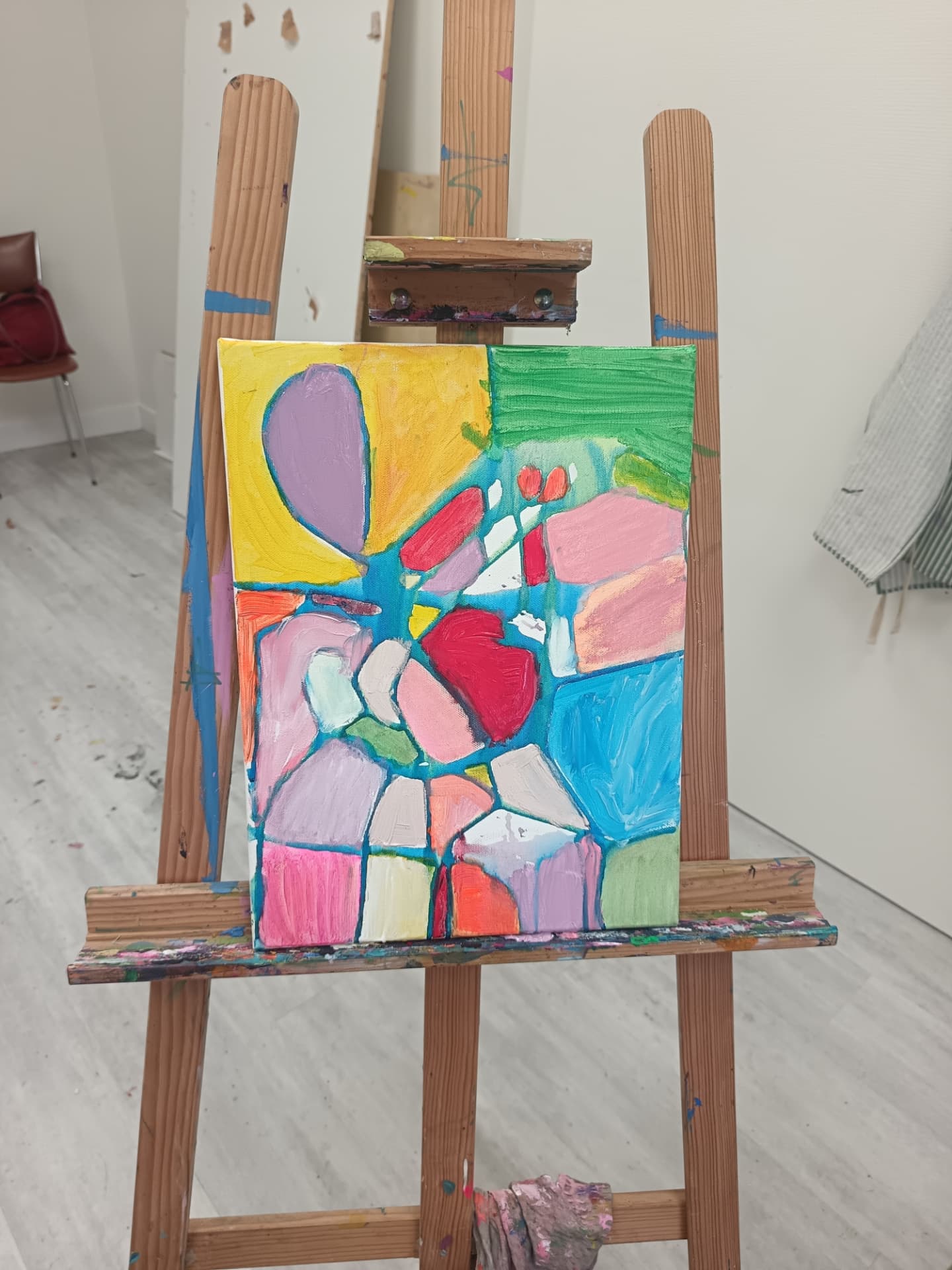 Peinture abstraite pastel aux formes cernées de bleu réalisée à l'atelier