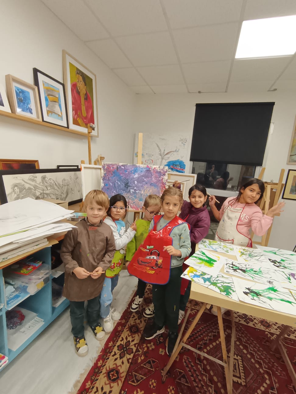 Groupe d'enfants en tabliers devant leurs créations à l'atelier