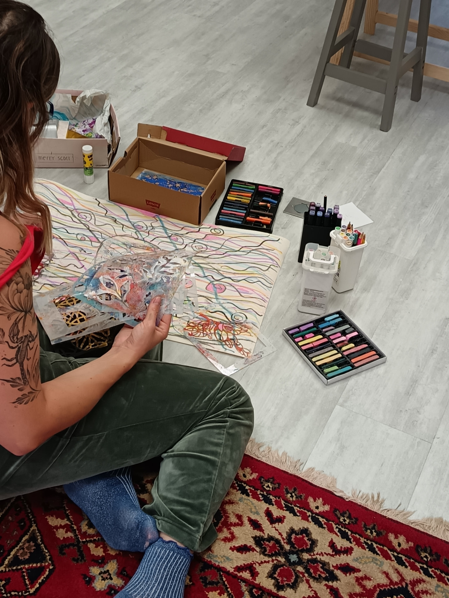 Participante réalisant un collage sur papier à l'atelier